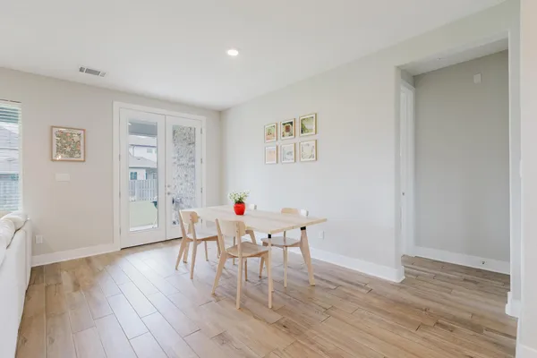 a view of a dining room with hardwood floor and an entryway
