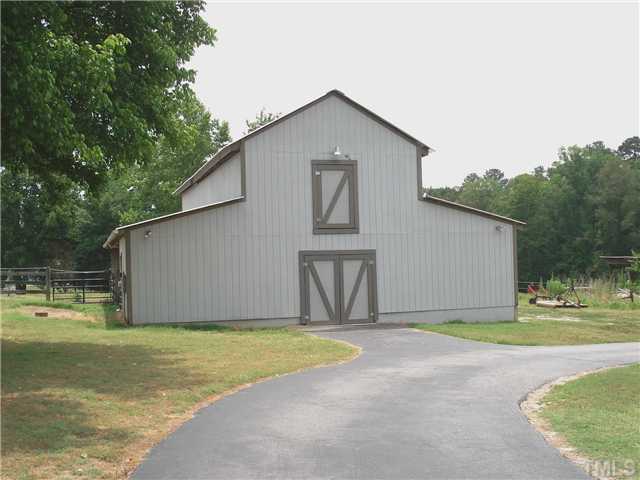 Two story barn with stalls and attached shelters houses the horses and tack for riding and hay for the horses.