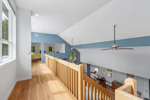 a view of a hallway with dining room and wooden floor