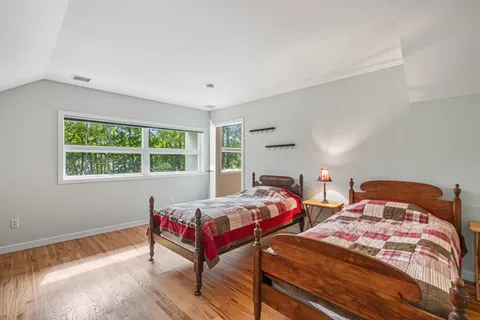 a bedroom with two beds and a window