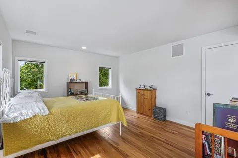 a bedroom with a bed and wooden floor
