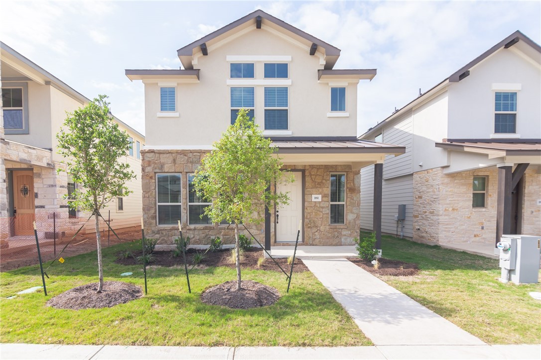 a front view of house with a yard and potted plants