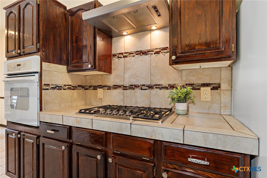 711 Mueller Street Copperas Cove, TX 76522 - Photo 17 of 48 a kitchen with granite countertop cabinets and black appliances