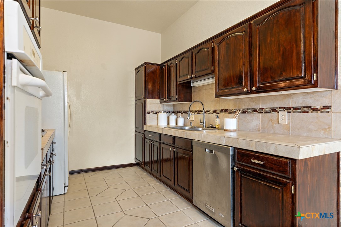 711 Mueller Street Copperas Cove, TX 76522 - Photo 18 of 48 a kitchen with stainless steel appliances granite countertop a sink stove and cabinets