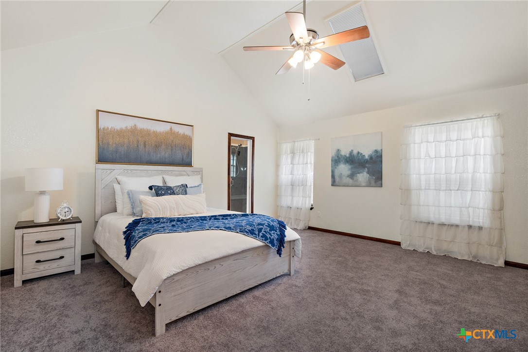 711 Mueller Street Copperas Cove, TX 76522 - Photo 19 of 48 a spacious bedroom with a bed and a chandelier