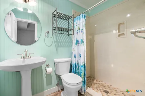 a bathroom with a toilet sink and mirror