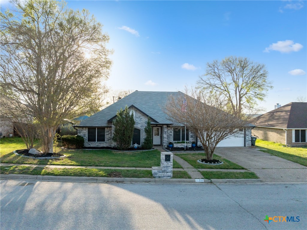 711 Mueller Street Copperas Cove, TX 76522 - Photo 3 of 48 a view of a white house with a big yard and large trees