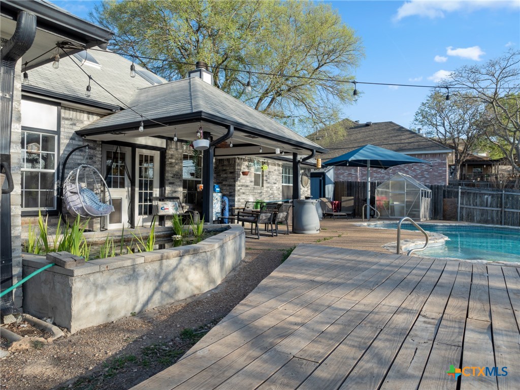 711 Mueller Street Copperas Cove, TX 76522 - Photo 38 of 48 a view of a patio with a table and chairs under an umbrella with a barbeque