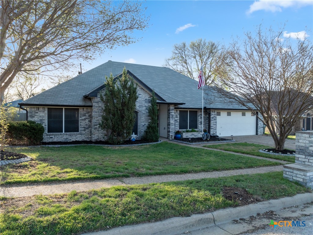 711 Mueller Street Copperas Cove, TX 76522 - Photo 4 of 48 a front view of a house with a garden and trees