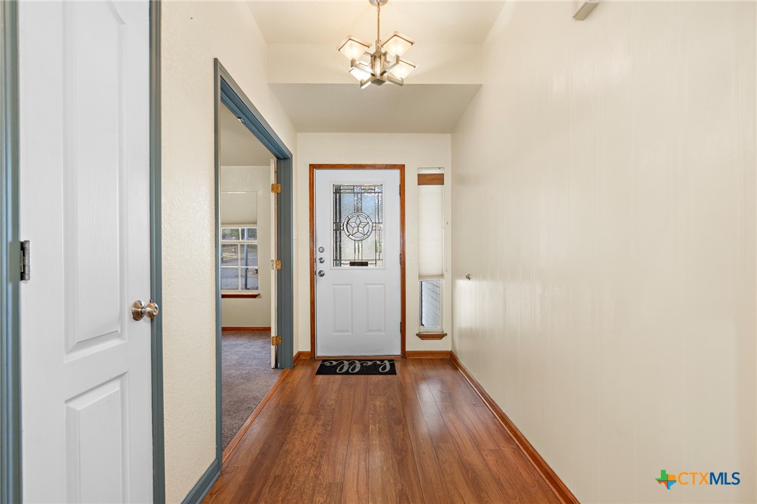 711 Mueller Street Copperas Cove, TX 76522 - Photo 8 of 48 a view of a hallway with wooden floor and a bathroom