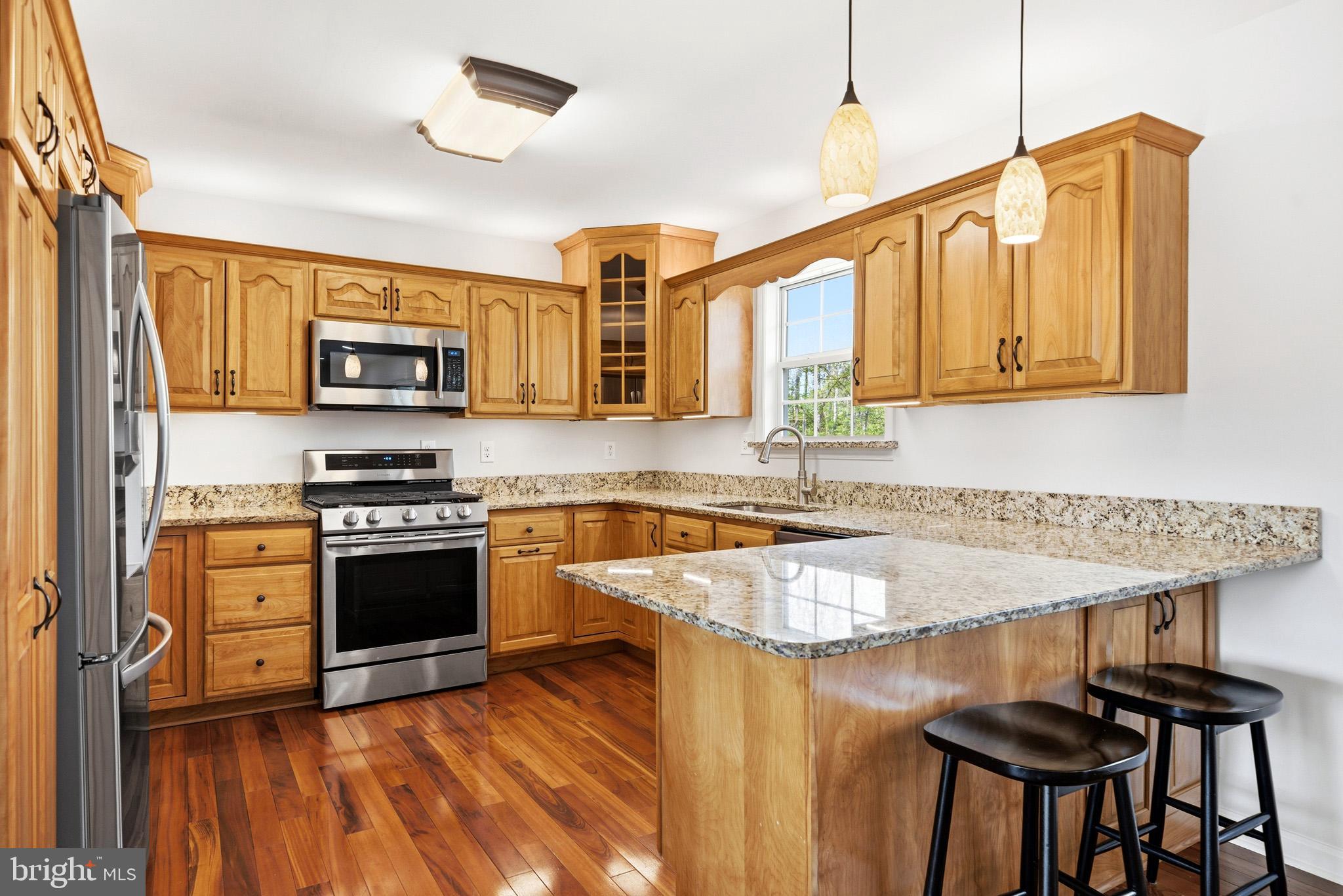 7219 Carrico Mill Road Hughesville, MD 20637 - Photo 11 of 41 a kitchen with stainless steel appliances granite countertop a stove a sink and a microwave