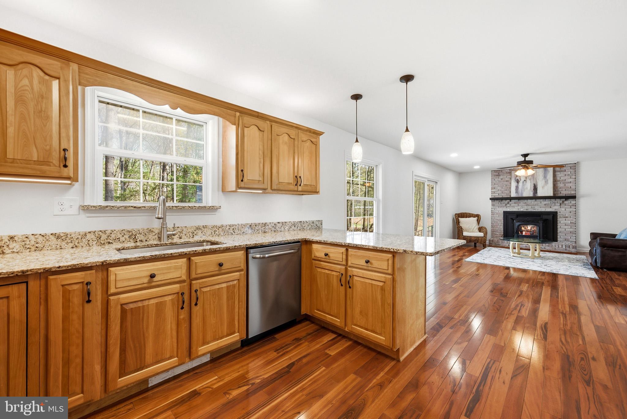 7219 Carrico Mill Road Hughesville, MD 20637 - Photo 12 of 41 a large kitchen with kitchen island granite countertop wooden floors and wide window