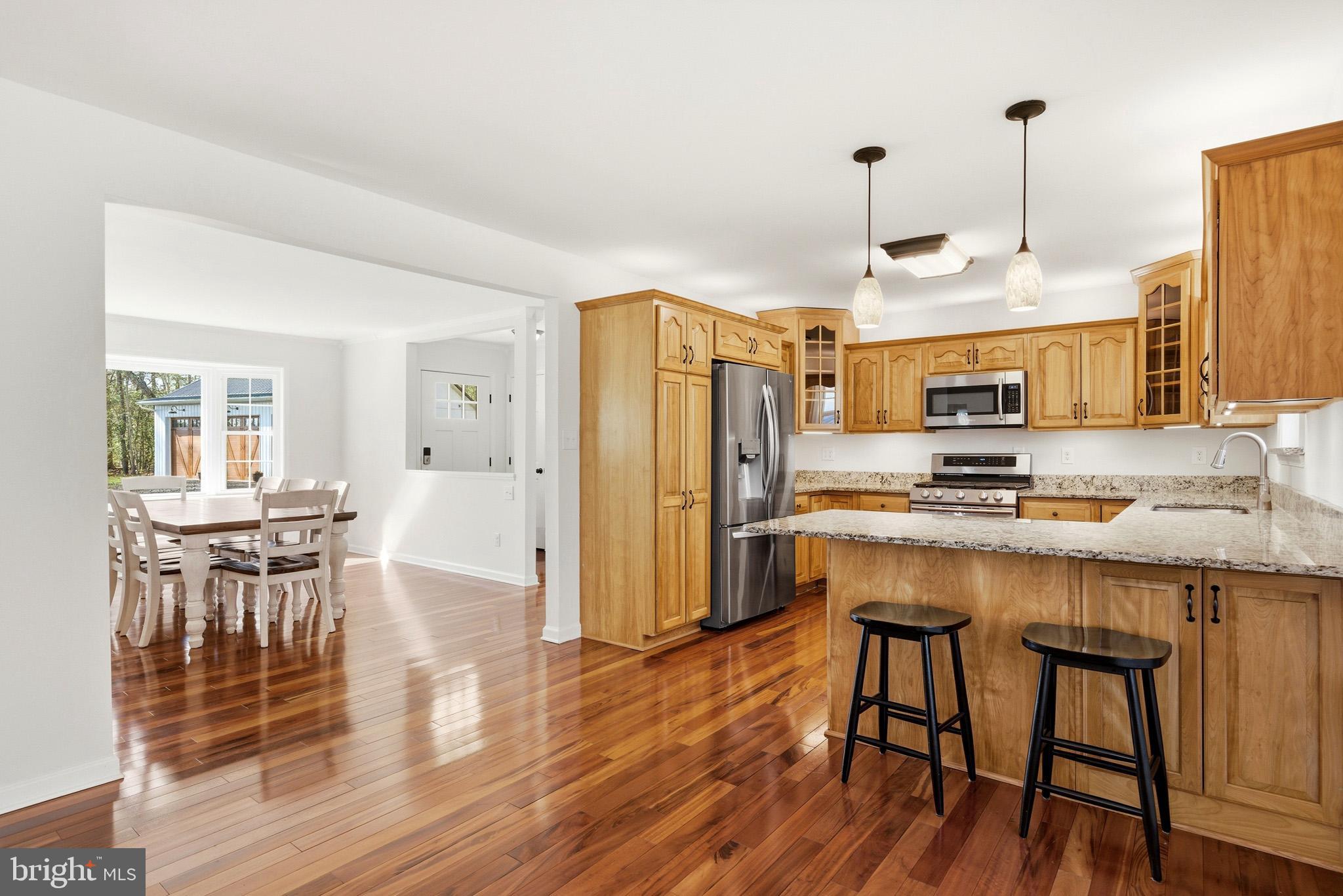 7219 Carrico Mill Road Hughesville, MD 20637 - Photo 9 of 41 a kitchen with stainless steel appliances granite countertop a kitchen island hardwood floor and a sink