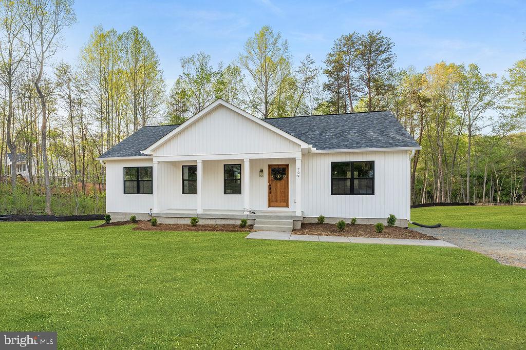 a front view of a house with a garden and trees