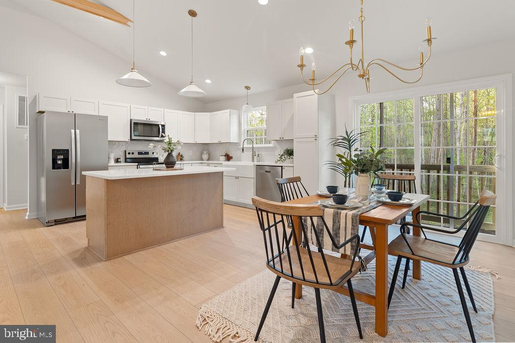 729 Vawter Corner Road Louisa, VA 23093 - Photo 12 of 50 a dining room with stainless steel appliances kitchen island granite countertop a dining table chairs and granite counter tops
