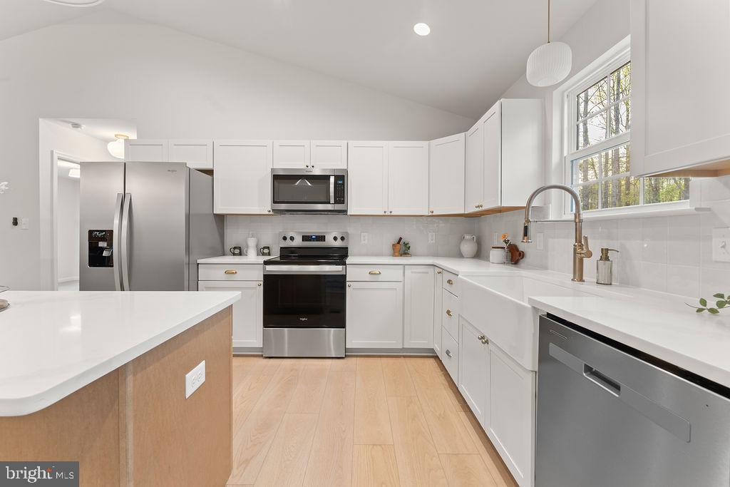 729 Vawter Corner Road Louisa, VA 23093 - Photo 15 of 50 a kitchen with stainless steel appliances a refrigerator sink and white cabinets