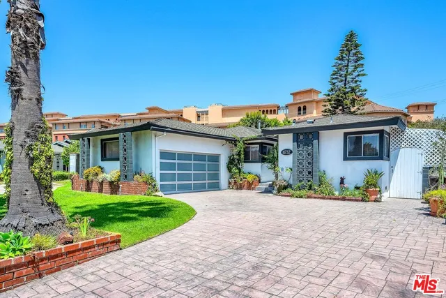 a front view of a house with a yard outdoor seating and garage