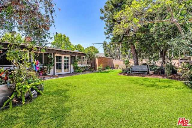 a view of a house with backyard sitting area and garden