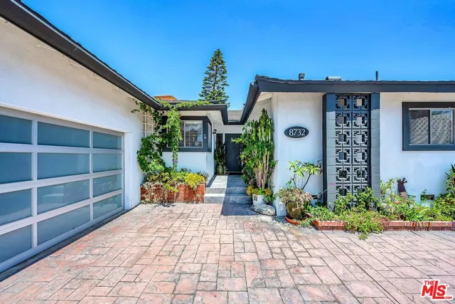 a front view of a house with potted plants
