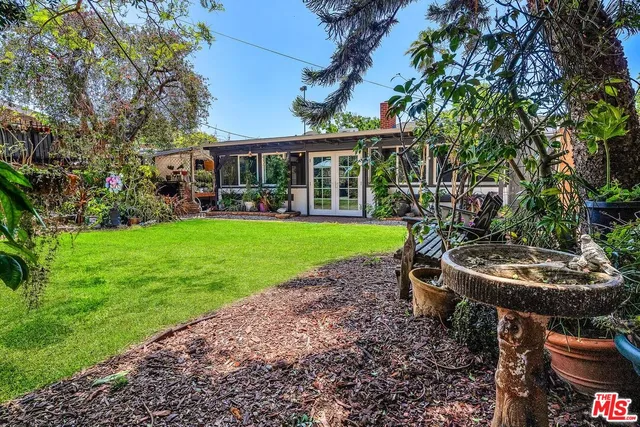 a view of a house with backyard sitting area and swimming pool