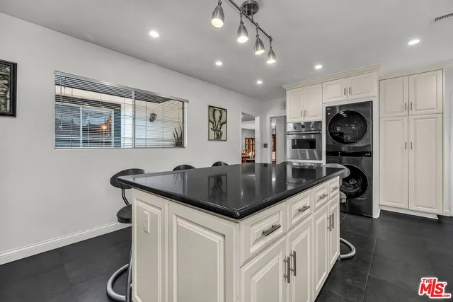 a kitchen with stainless steel appliances granite countertop a sink and a refrigerator