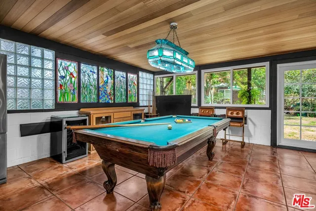 a room with pool table and windows