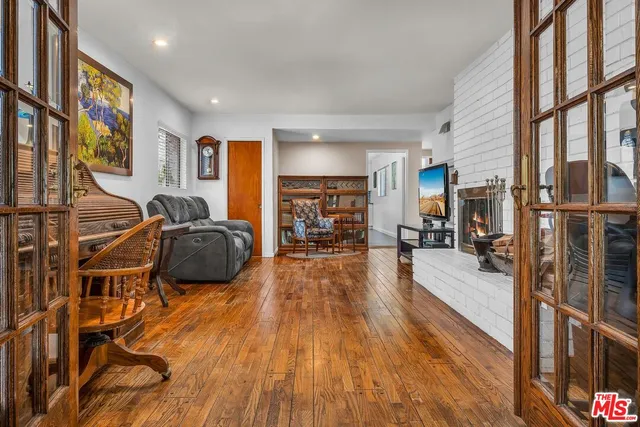 a living room with furniture a wooden floor and a large window