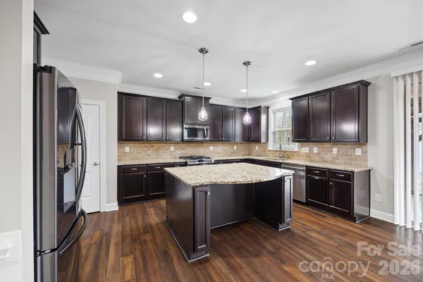 a open kitchen with stainless steel appliances granite countertop a stove refrigerator and a sink