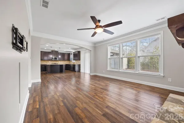 a view of empty room with wooden floor and window