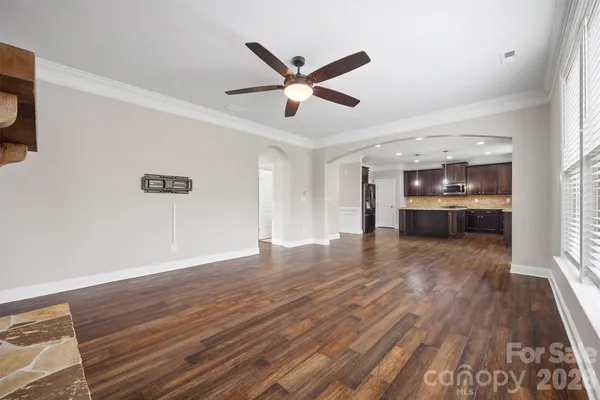 a view of empty room with wooden floor and ceiling fan