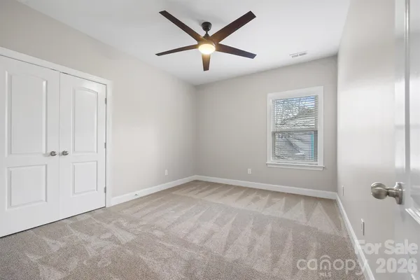 an empty room with chandelier fan