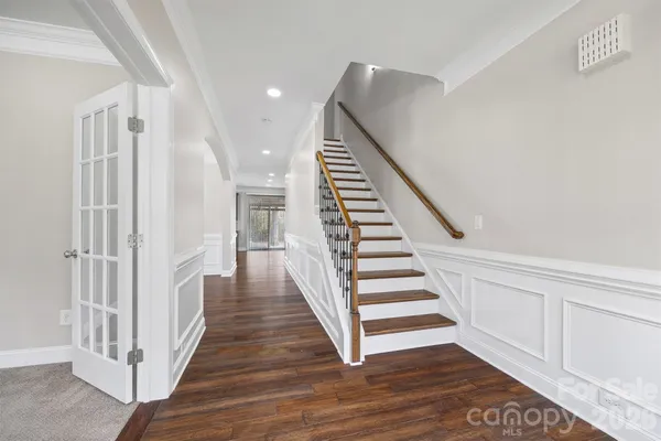 a view of a hallway with wooden floor and entryway