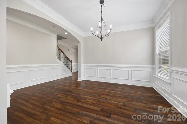 a view of empty room with wooden floor fan and window
