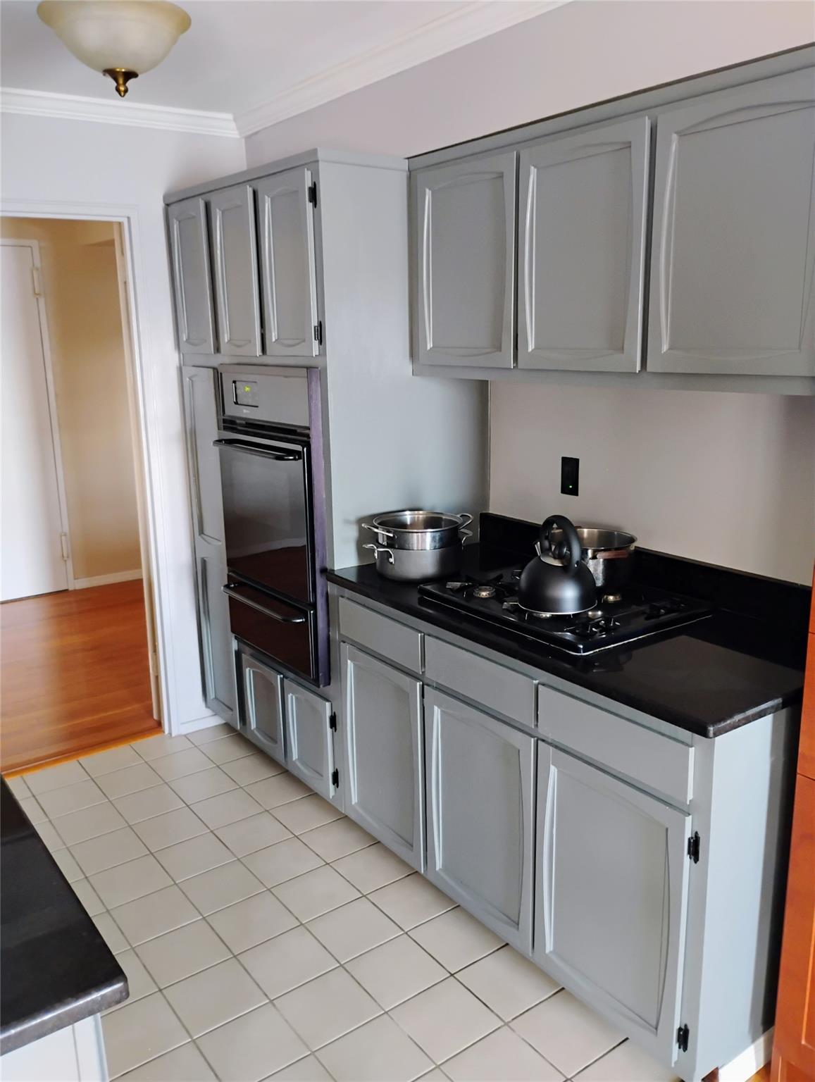 103 Gedney Street, Unit 3B Nyack, NY 10960 - Photo 3 of 11 Kitchen featuring dark countertops, black appliances, gray cabinets, crown molding, and a warming drawer