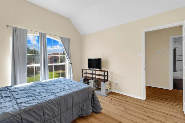 a bedroom with a bed and a flat tv screen on dresser