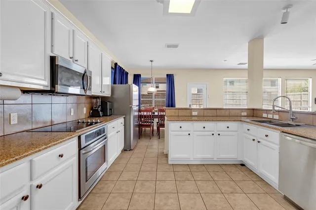 a kitchen with granite countertop cabinets stainless steel appliances a sink and a counter space
