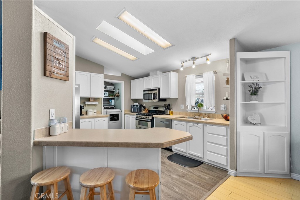 30000 Hasley Canyon Road, Unit 88 Castaic, CA 91384 - Photo 14 of 33 a kitchen with white cabinets and chairs