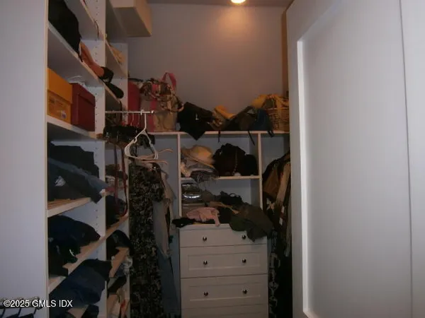 a view of walk in closet with clothes and shoes