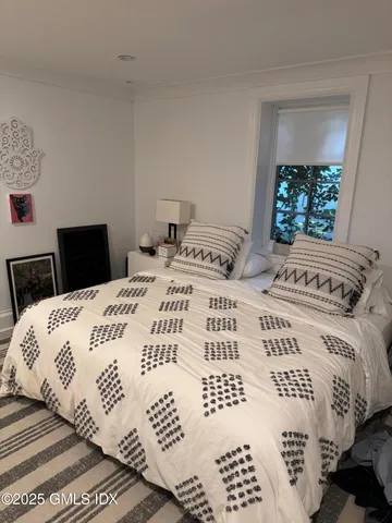 a bedroom with a large bed and a window