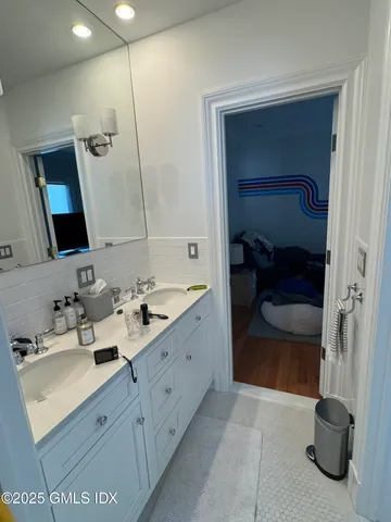 a en suite bathroom with a double vanity sink and a mirror