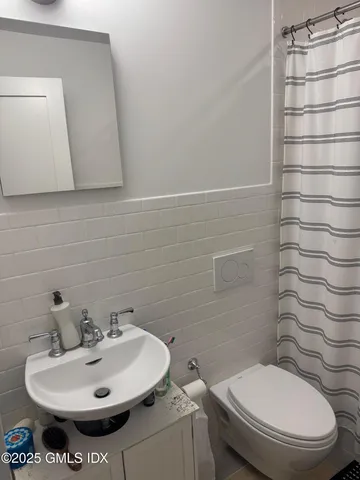a bathroom with a sink a toilet and mirror