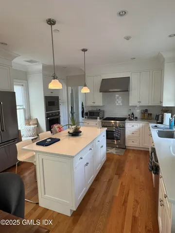 a kitchen with stainless steel appliances kitchen island a sink stove and refrigerator