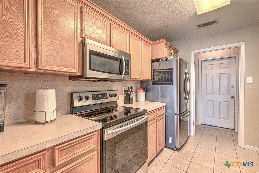 5004 Sunrise Street Killeen, TX 76542 - Photo 11 of 29 a kitchen with stainless steel appliances granite countertop a stove a refrigerator and a microwave