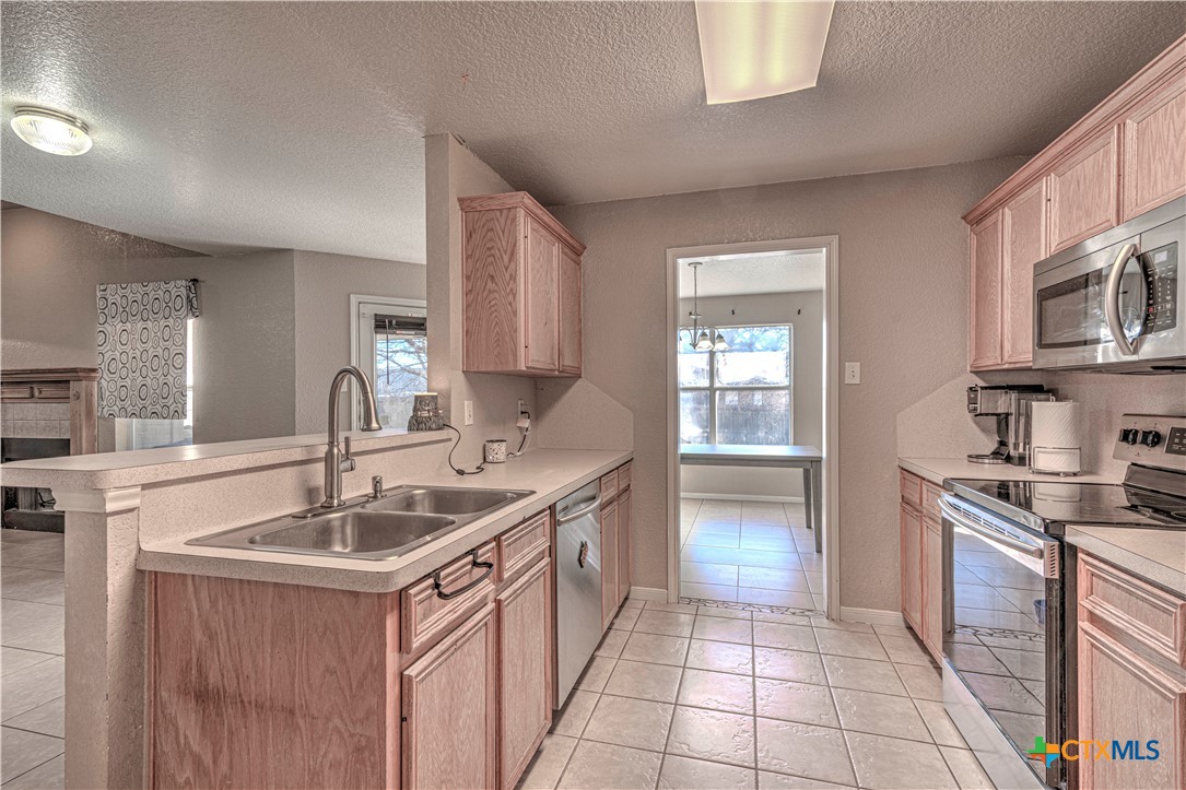 5004 Sunrise Street Killeen, TX 76542 - Photo 13 of 29 a kitchen with a sink stove and cabinets