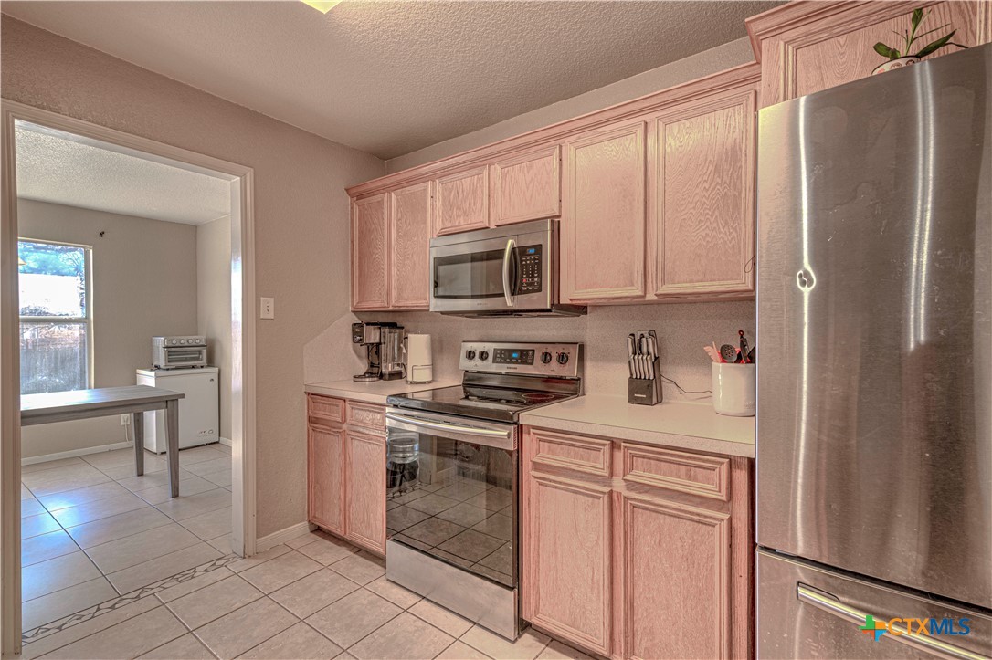 5004 Sunrise Street Killeen, TX 76542 - Photo 14 of 29 a kitchen with stainless steel appliances granite countertop a refrigerator sink and cabinets