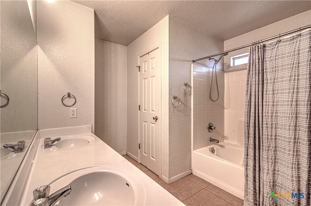 5004 Sunrise Street Killeen, TX 76542 - Photo 18 of 29 a bathroom with a sink a bath tub and a glass door shower