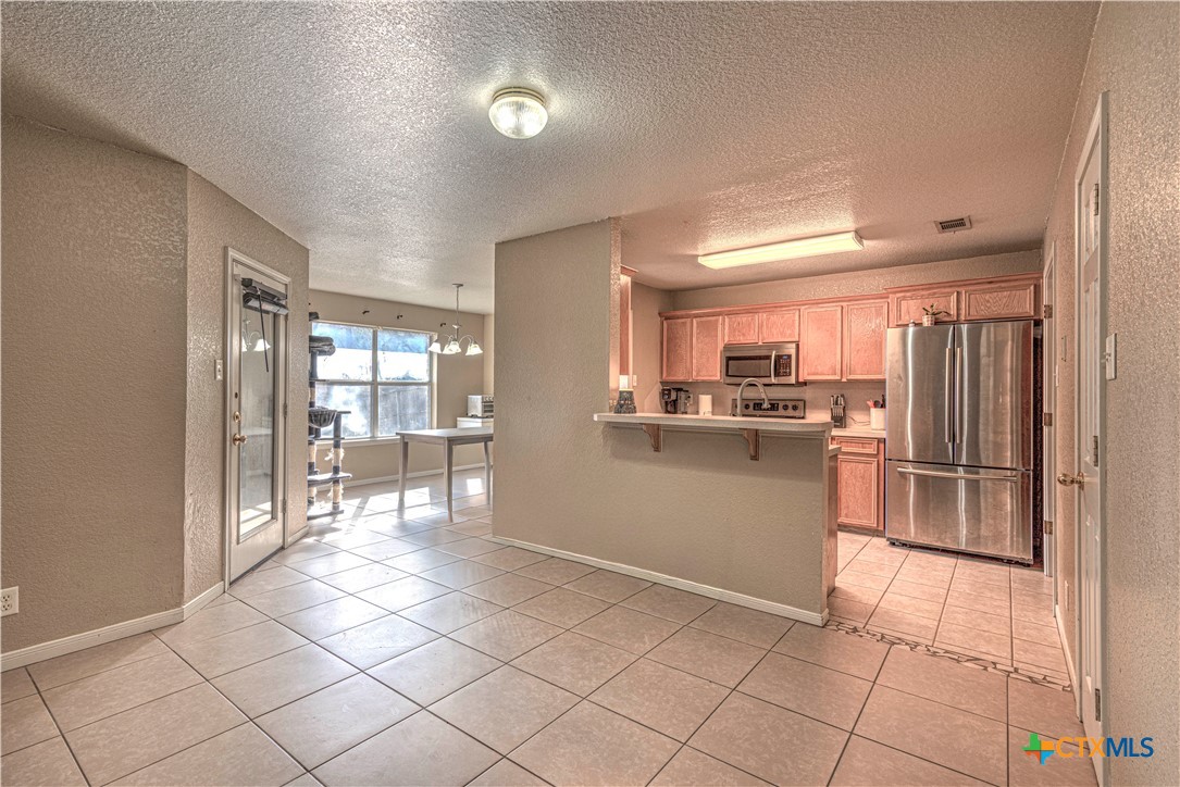 5004 Sunrise Street Killeen, TX 76542 - Photo 7 of 29 a kitchen with a refrigerator and white cabinets