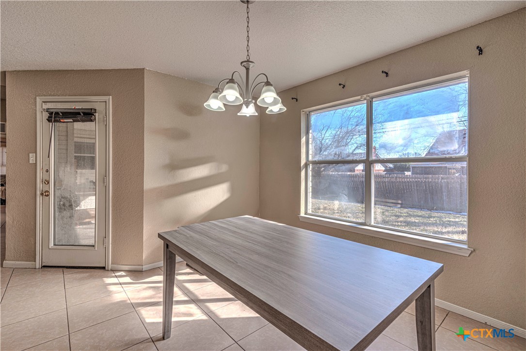 5004 Sunrise Street Killeen, TX 76542 - Photo 9 of 29 a dining room with wooden floor a chandelier a wooden table and chairs