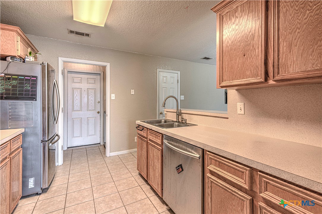 5004 Sunrise Street Killeen, TX 76542 - Photo 10 of 29 a kitchen with a sink a refrigerator and cabinets