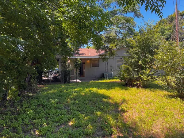 a view of a house with a yard garage and a tree